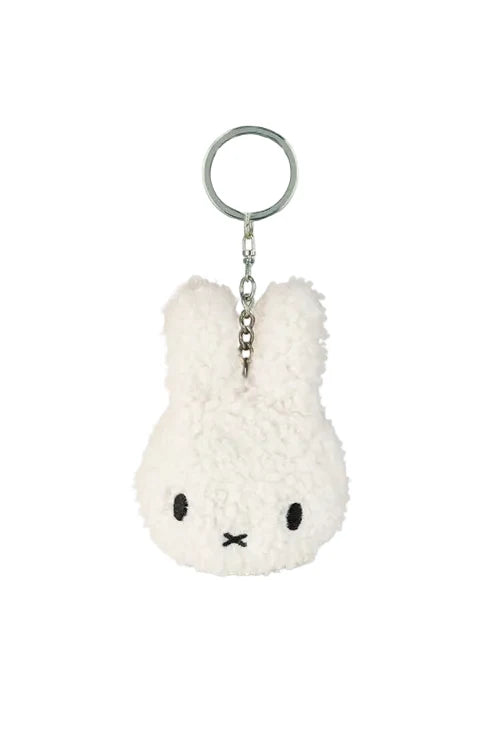 White plush keychain with a face on a white background