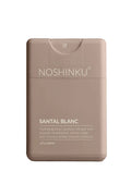 Noshinku Santal Blanc hand sanitizer packaging on a brown background