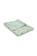A folded light mint green waffle-weave muslin blanket with a colorful pattern of small yellow mushrooms, red mushrooms, shown on a clean white background.