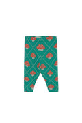 A pair of toddler leggings with a green background, featuring a repeating pattern of red and white mushrooms and thin white diagonal lines.