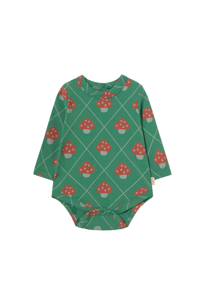 A long-sleeve baby bodysuit with a green base featuring a repeating pattern of red and white mushrooms inside a diamond grid, shown on a plain off-white background.