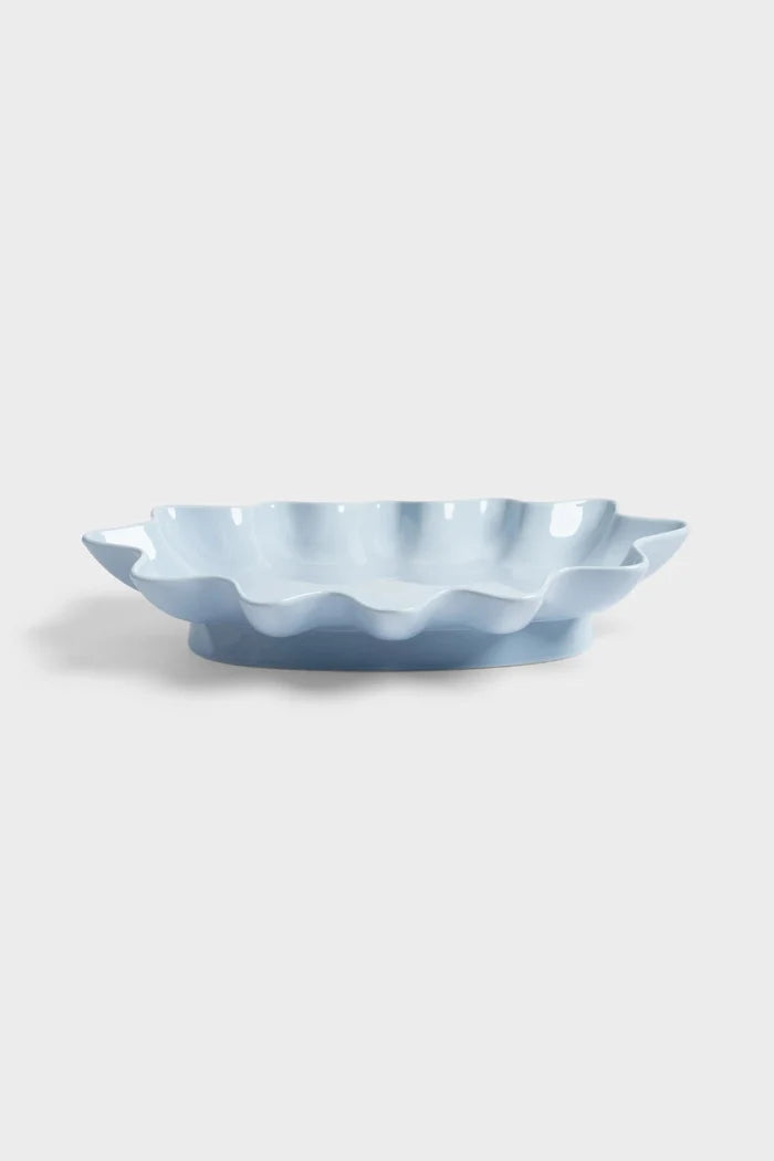 Light blue ceramic bowl with wavy edge on a white background