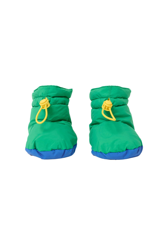 A pair of bright green puffer-style booties with blue soles and yellow drawstring loops, shown on a clean white background.