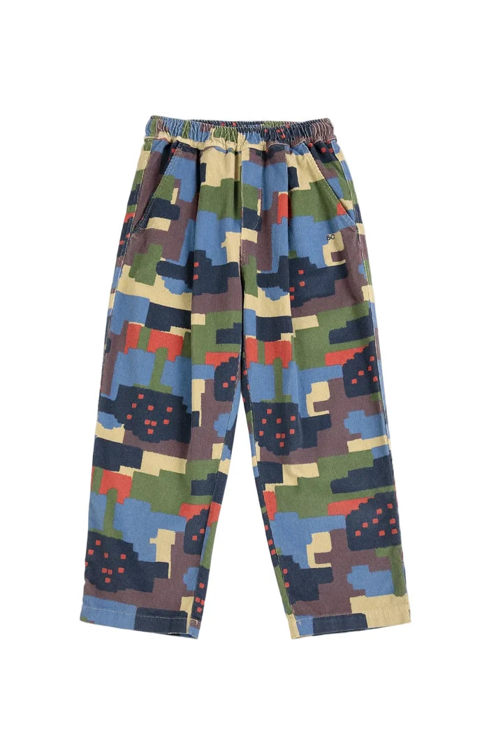 A pair of children's jogger-style pants with an elastic waistband, featuring a colorful pixelated camouflage pattern in blue, green, beige, brown, and red, shown flat against a light gray background.