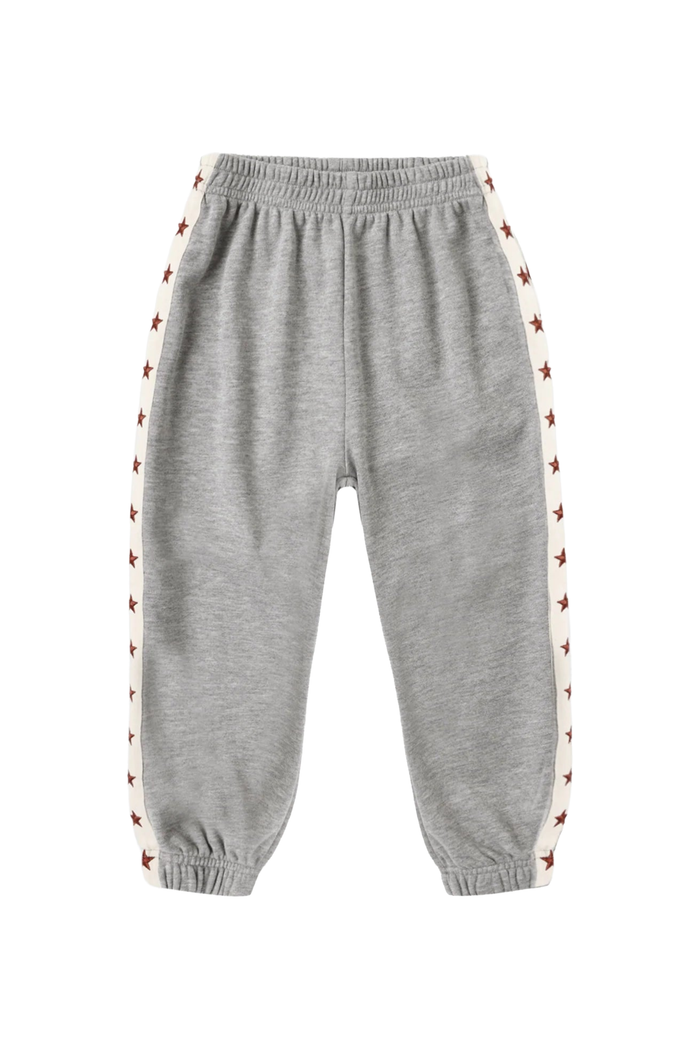 A pair of kids' heather gray sweatpants with white side stripes featuring a repeating pattern of small red stars, shown against a plain white background.