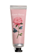 Hand cream tube with pink packaging and floral design on a white background