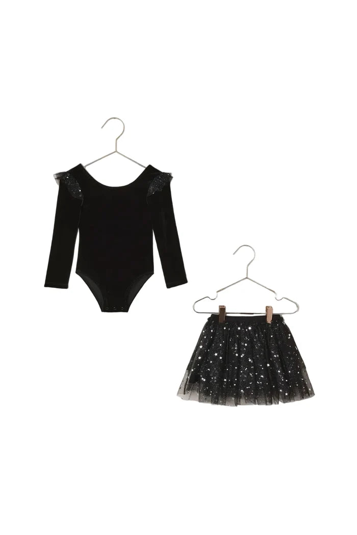 Black velvet bodysuit with sheer sleeves and black sequin skirt on hangers against a beige background