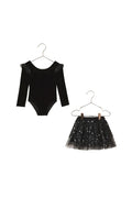 Black velvet bodysuit with sheer sleeves and black sequin skirt on hangers against a beige background