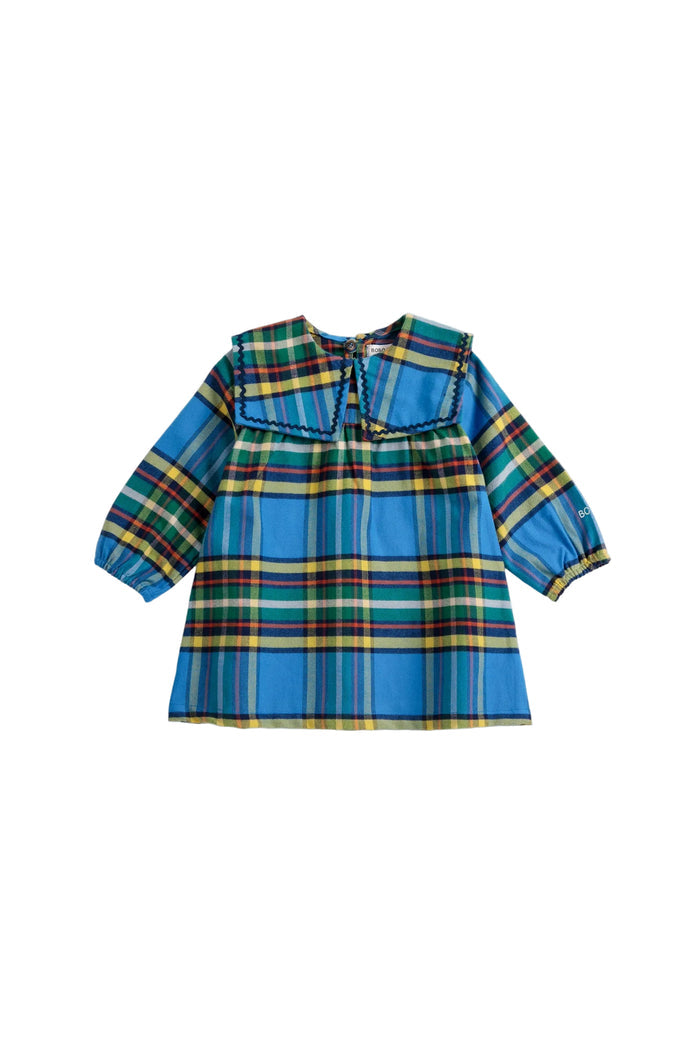 A toddler girl's long-sleeve plaid blouse in blue, green, yellow, and red tartan, featuring a wide decorative collar with black lace trim and gathered cuffs.
