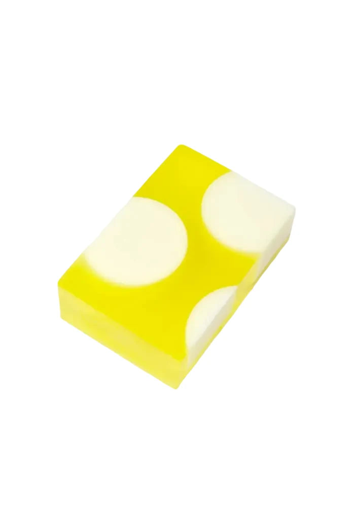 A rectangular translucent yellow soap bar with two large white circular sections, photographed on a plain white background.
