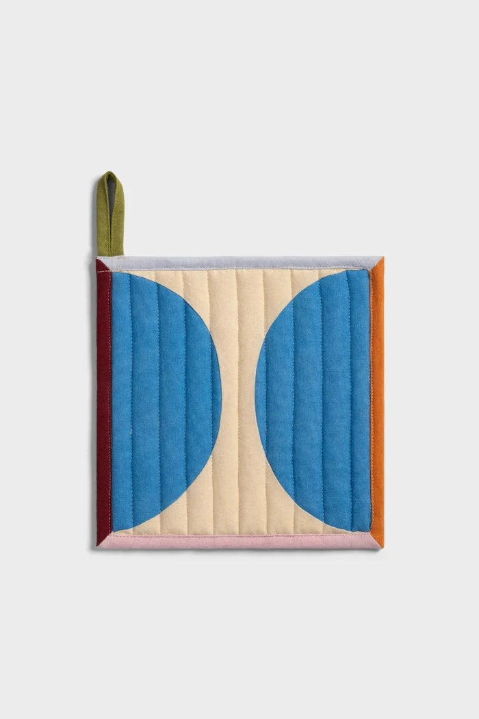 Quilted pot holder with graphic, colorful design on white background