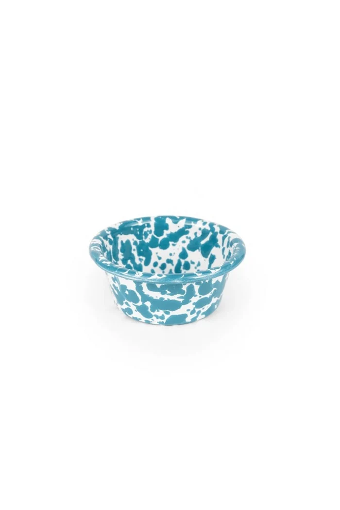 Small turquoise and white enamelware ramekin on white background