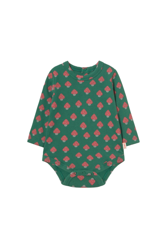A long-sleeve baby bodysuit in dark green with a repeating pink mushroom pattern, laid flat against a light cream background.
