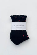 Pair of black socks with ruffles edge and flower print on white background