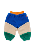 A pair of children's sherpa jogger pants in a color-blocked design with blue, beige, green, and orange sections, shown flat on a white background.