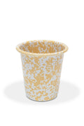 Enamelware cup with yellow and white pattern on a white background