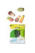 A bag of Swedish candy Sockerbit with several colorful, sugar-coated gummy candies scattered above it on a plain white background.
