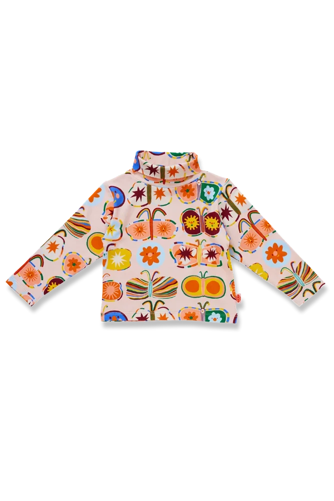 A long-sleeve turtle neck top with a colorful butterfly and flower pattern on a light pinkish-beige background, shown flat against a white background.