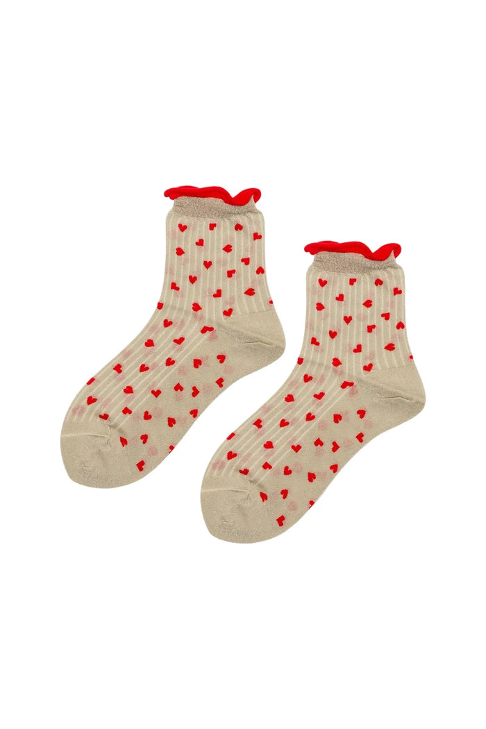 A pair of beige ankle socks with a pattern of small red hearts and red ruffled trim at the top, displayed against a plain white background.