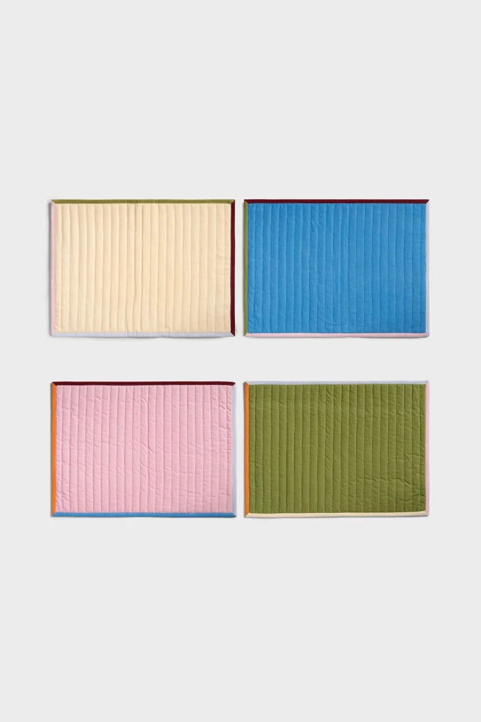 Four multicolor quilted placemats on white background