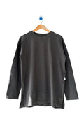 A dark charcoal gray long-sleeve crewneck shirt hanging on a wooden hanger against a plain off-white wall.