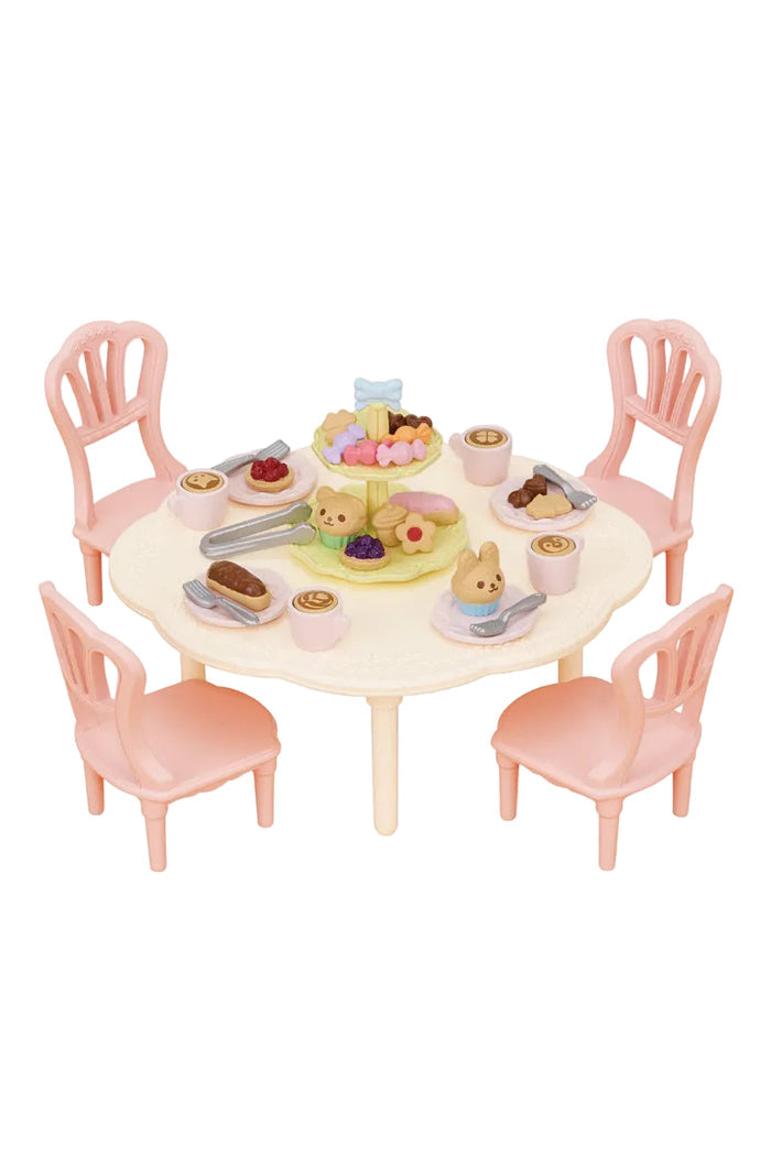 Toy table set with chairs and miniature food items on a white background
