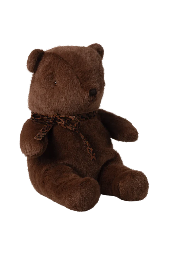 Brown teddy bear with a leopard print bow on a white background