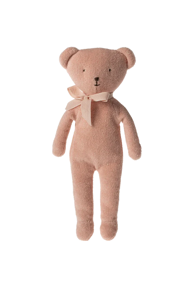 Pink teddy bear with a bow tie against a striped background