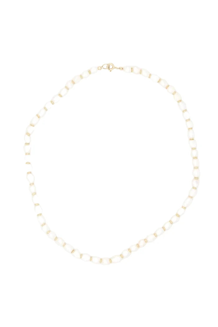 A delicate gold chain necklace with small, evenly spaced white pearl-like beads, arranged in a circle on a solid white background.