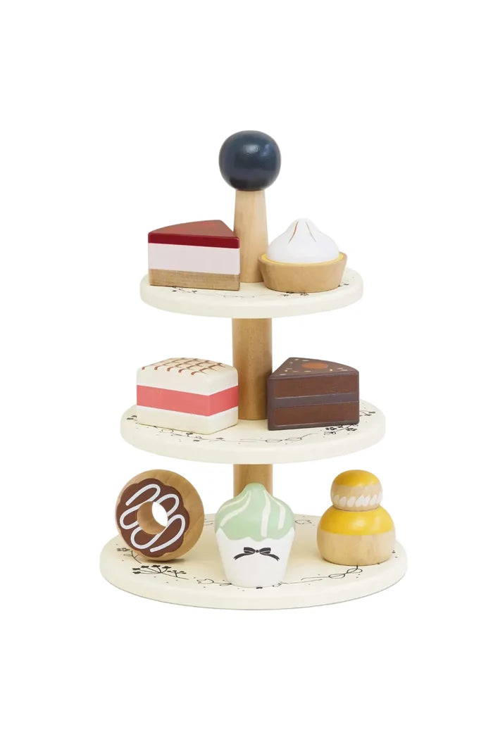 Wooden toy cake stand with various dessert models on a white background