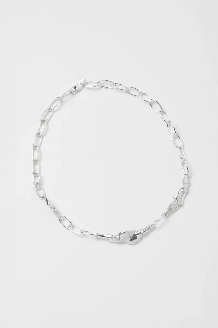 Silver chain necklace on a light gray background