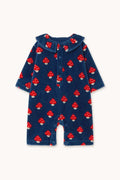 A baby long-sleeve romper in navy blue corduroy fabric, featuring an all-over red and white mushroom print, displayed flat against a light cream background.