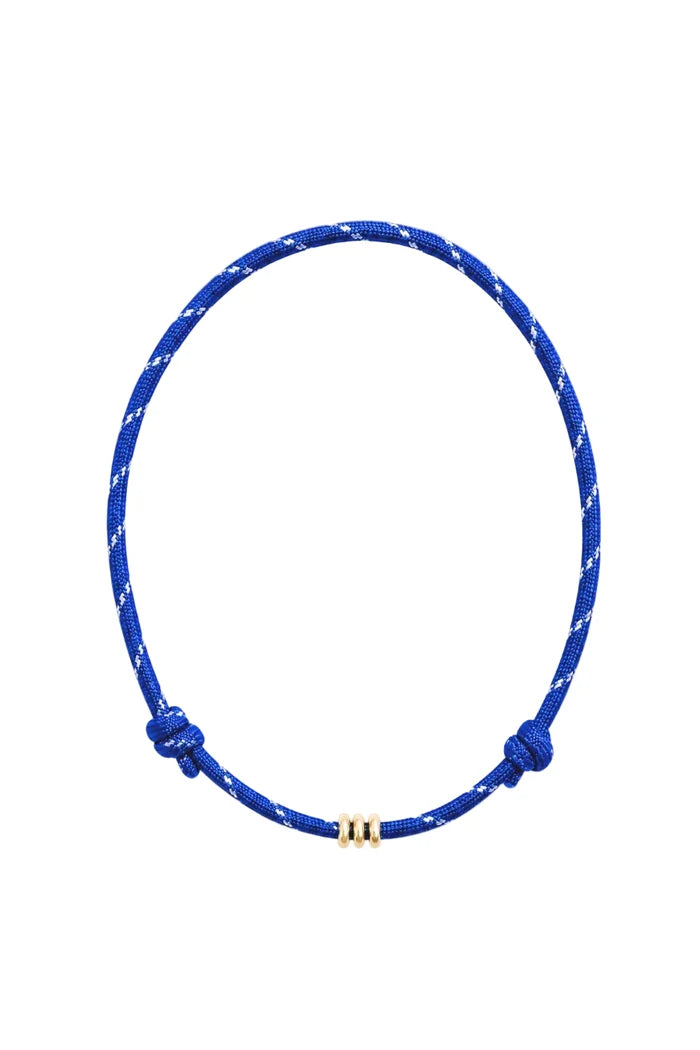 A blue and white braided cord necklace with adjustable knot ends and a small gold bead clasp, displayed on a clean white background.