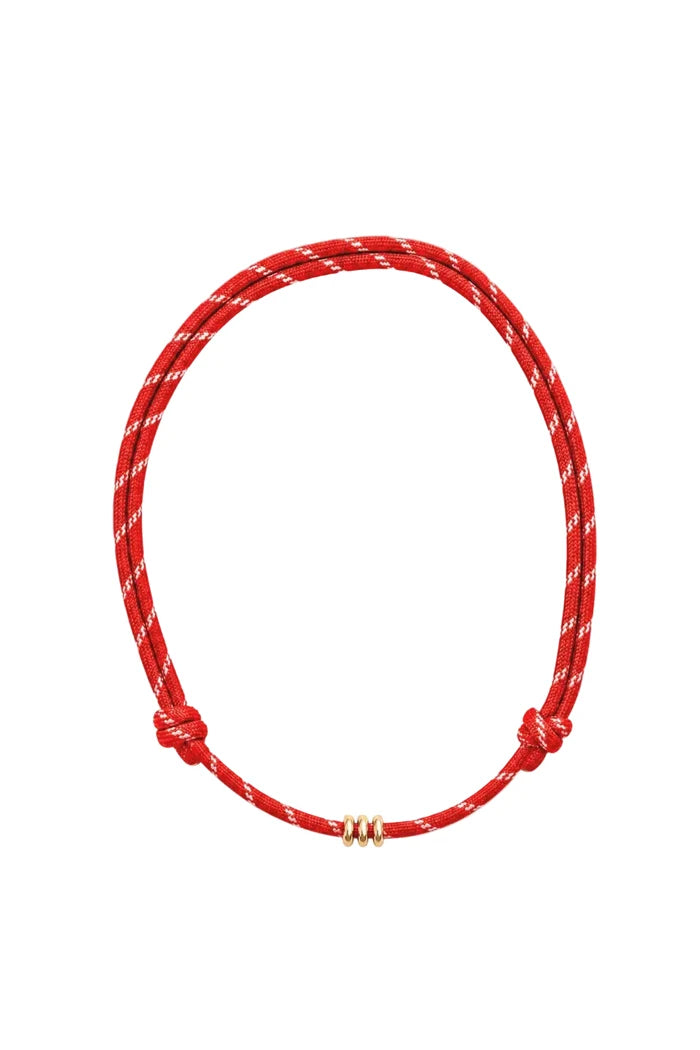 A red adjustable cord necklace with a white woven pattern and three small gold spacer beads, shown on a plain white background.