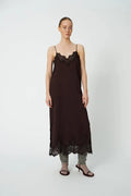 Woman wearing a brown slip dress with lace details on a white background