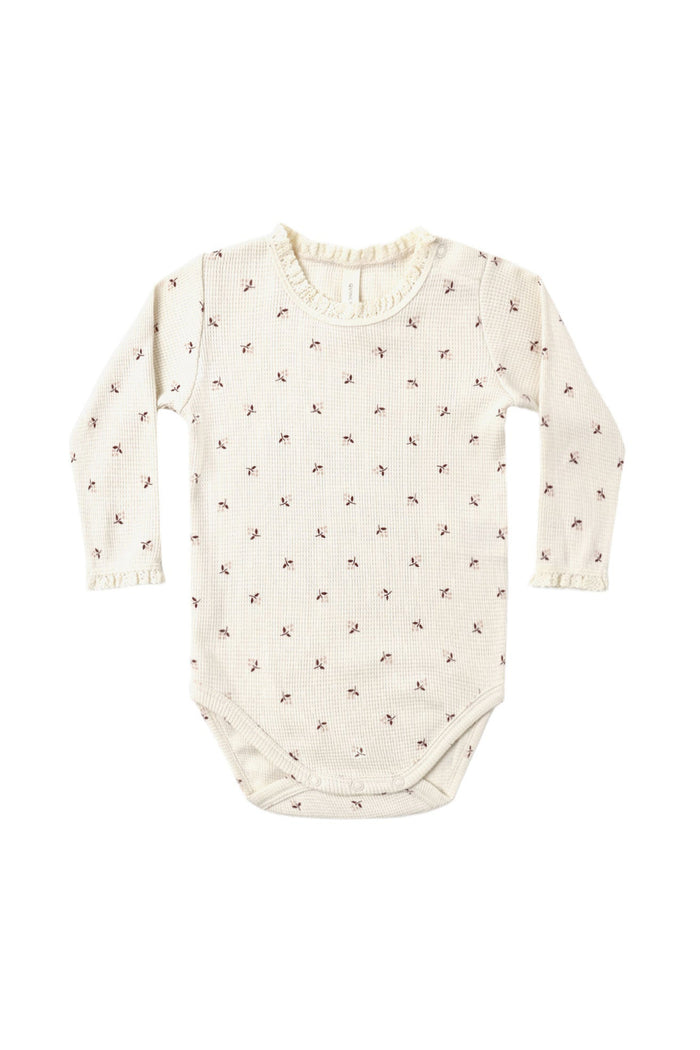 A long-sleeve baby bodysuit in cream with a small brown floral print, displayed flat against a solid white background.