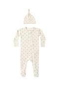 A baby sleep suit and matching knotted beanie hat in a warm cream color with a small brown daisy print, displayed flat against a solid white background.