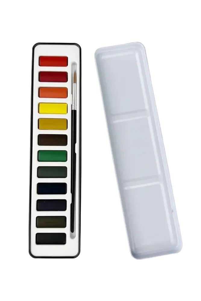 Set of watercolor paints with a brush in a transparent case on a light gray background