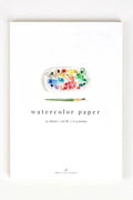 Watercolor paper set with a paint palette and brush on a white background