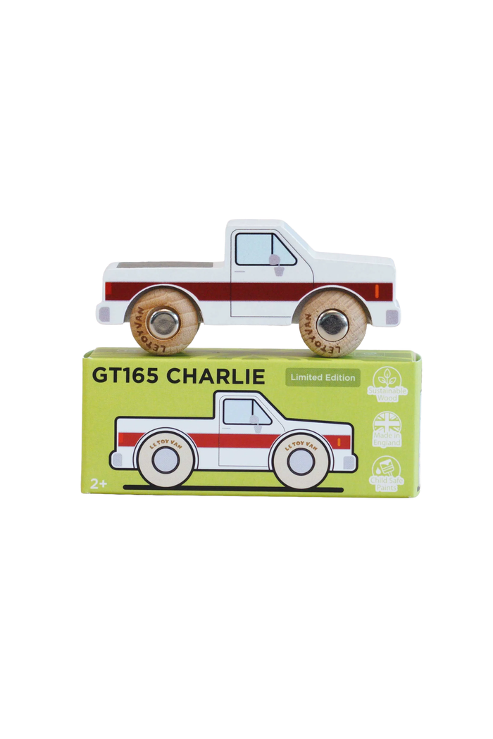 A wooden toy pickup truck labeled GT165 CHARLIE sits on top of its light green packaging box against a plain white background.