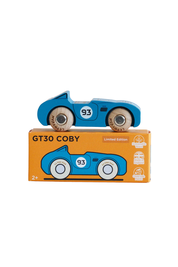 A blue wooden toy race car with the number 93 sits on top of its orange retail box labeled GT30 COBY. The box also shows a matching illustration of the car and small product icons on a white background.
